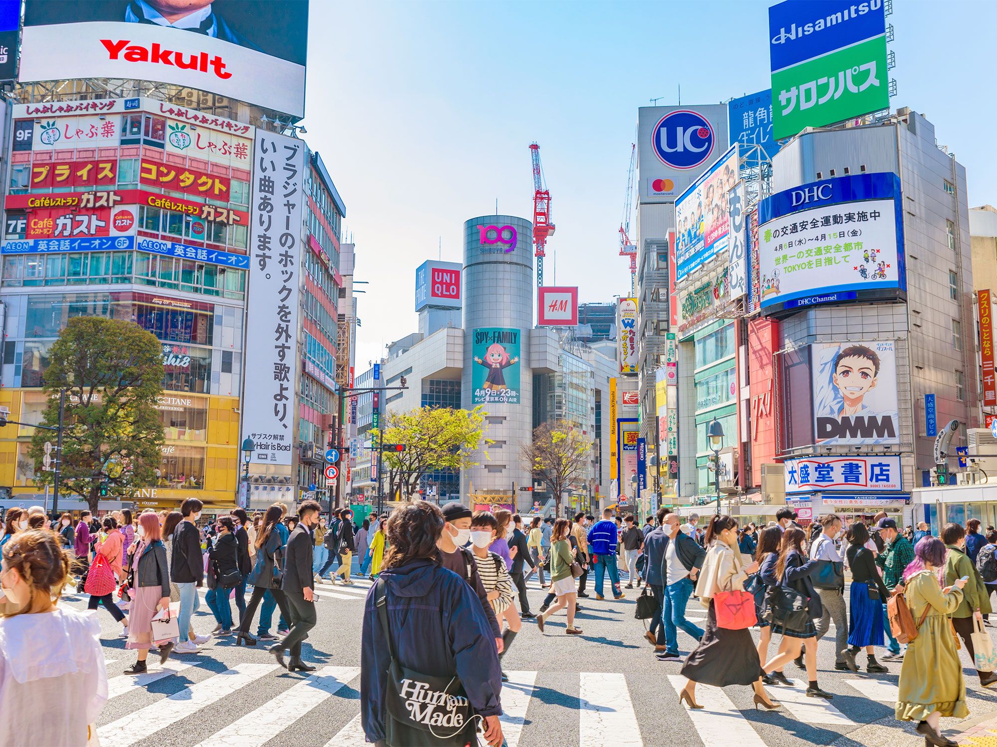 Busy street crossing filled with pedestrians and billboards in Tokyo, Japan