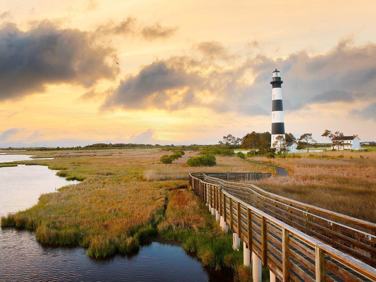 Wooden pathway leading to striped lighthouse on Roanoke Island, North Carolina