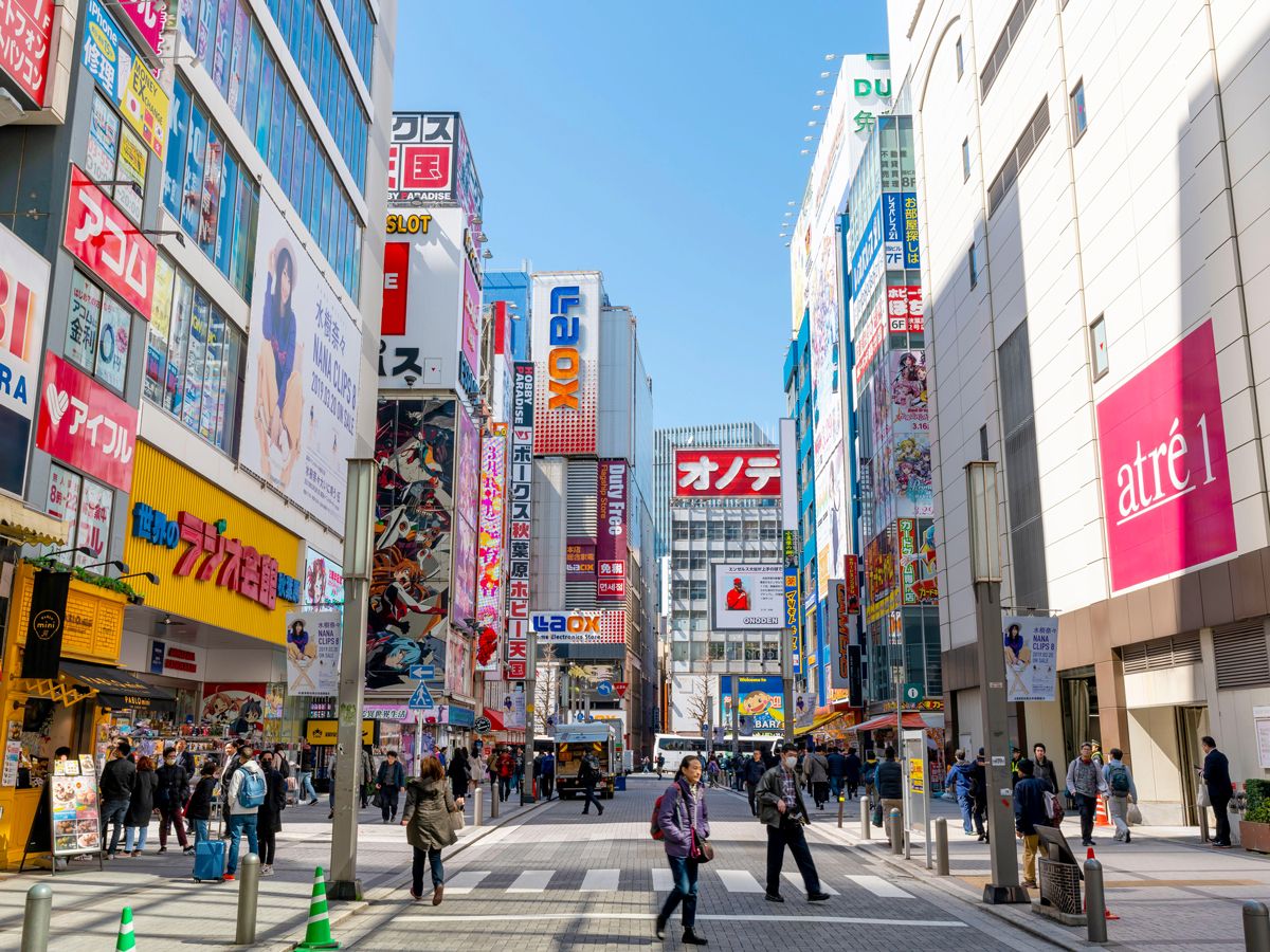 Pedestrian-filled Tokyo street lined with billboards
