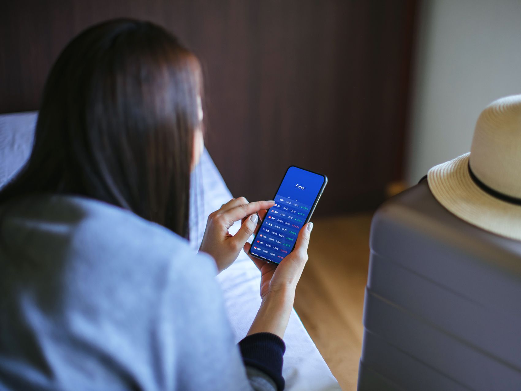 Person sitting on bed browsing phone