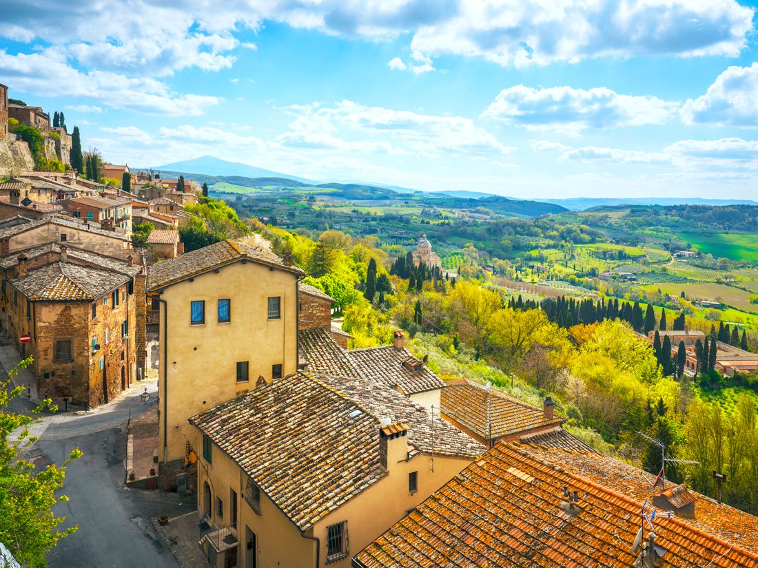 Homes with red-tiled roofs overlooking hills of Tuscany, Italy