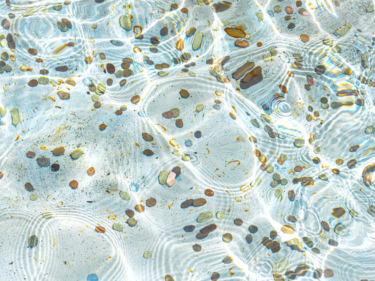 Close-up view of coins at the bottom of Rome's Trevi Fountain