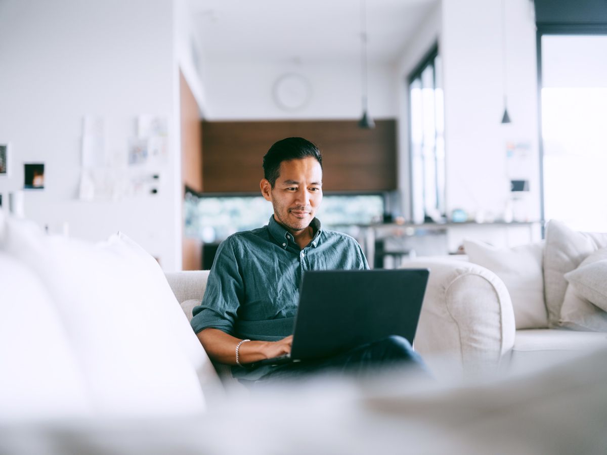 Person sitting on couch typing on laptop computer
