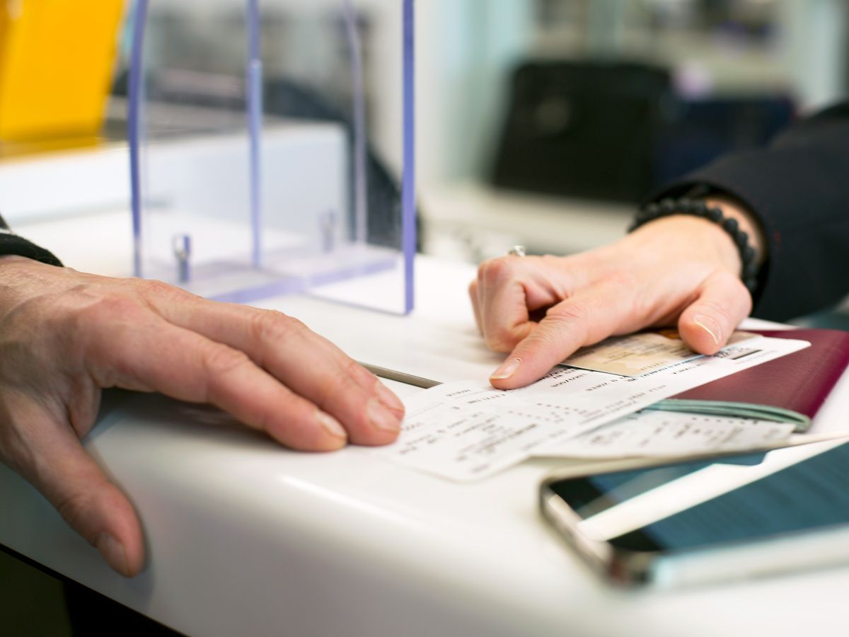 Gate agent pointing to passenger's boarding pass