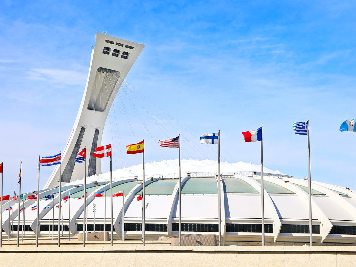Montreal Tower leaning at an angle as flags fly over Olympic Stadium