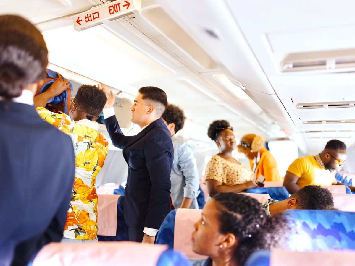 Passengers standing in aircraft aisle