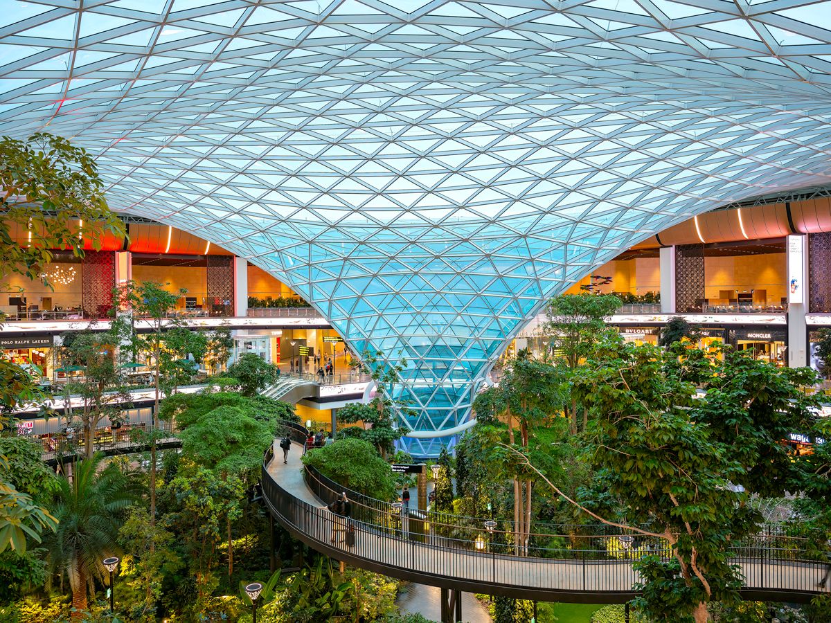 Glass dome above elevated walkway and indoor garden at Doha's Hamad International Airport