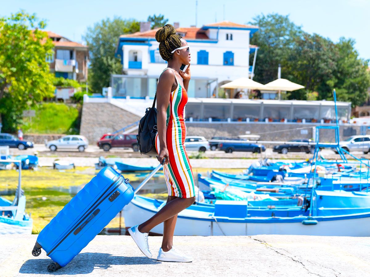 Cruise passenger rolling suitcase on dock