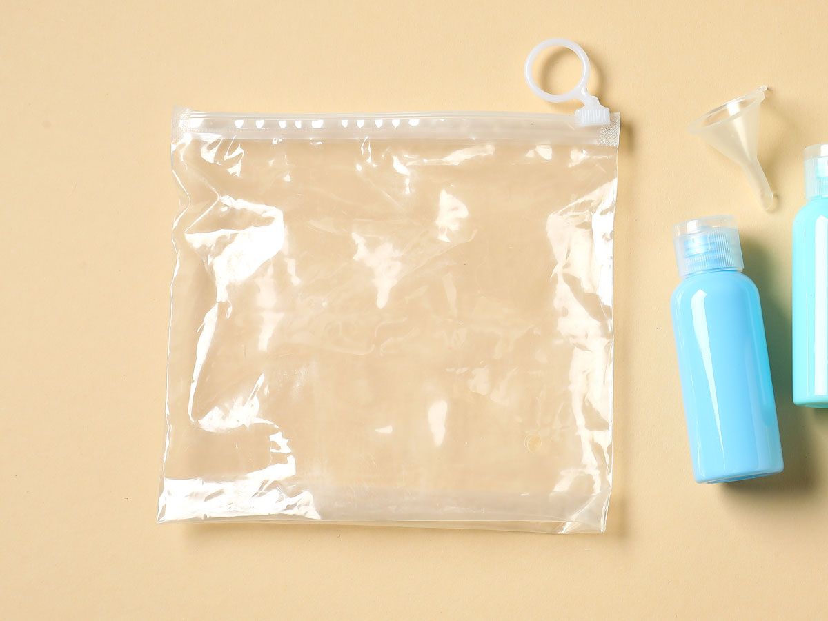 Clear plastic bag and small reusable toiletry bottle on table