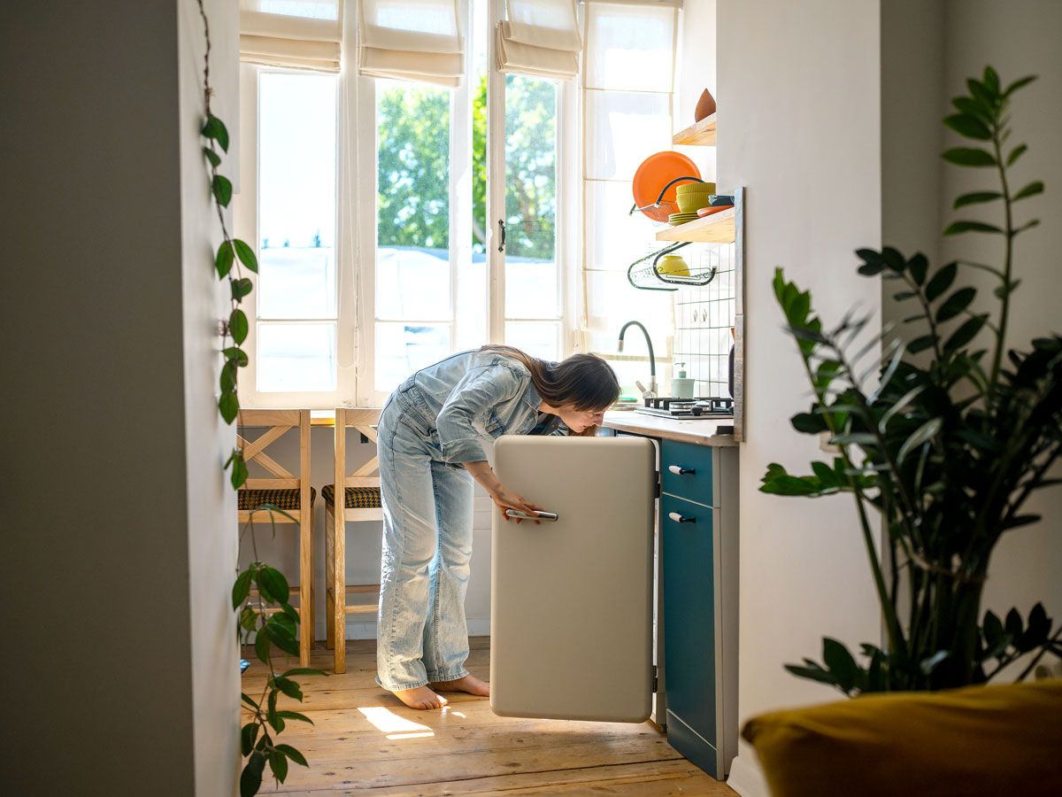 Person reaching into freezer in kitchen