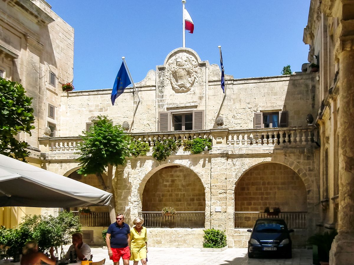 People walking in front of Xara Palace in Mdina, Malta