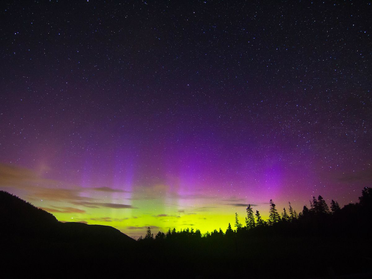 Northern lights seen over treetops and mountains in Maine