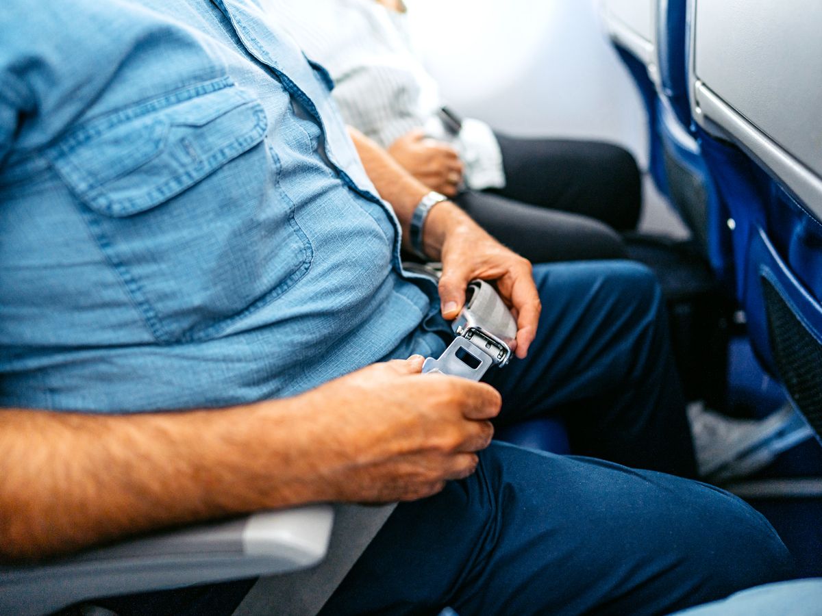Passenger buckling seatbelt on airplane