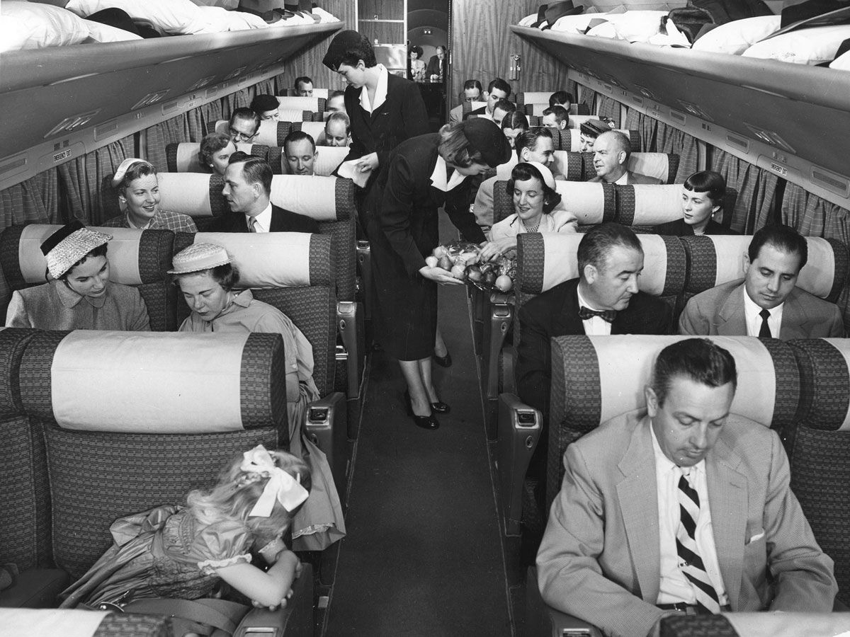 Historical images of well-dressed passengers on a DC-7 airplane in 1955