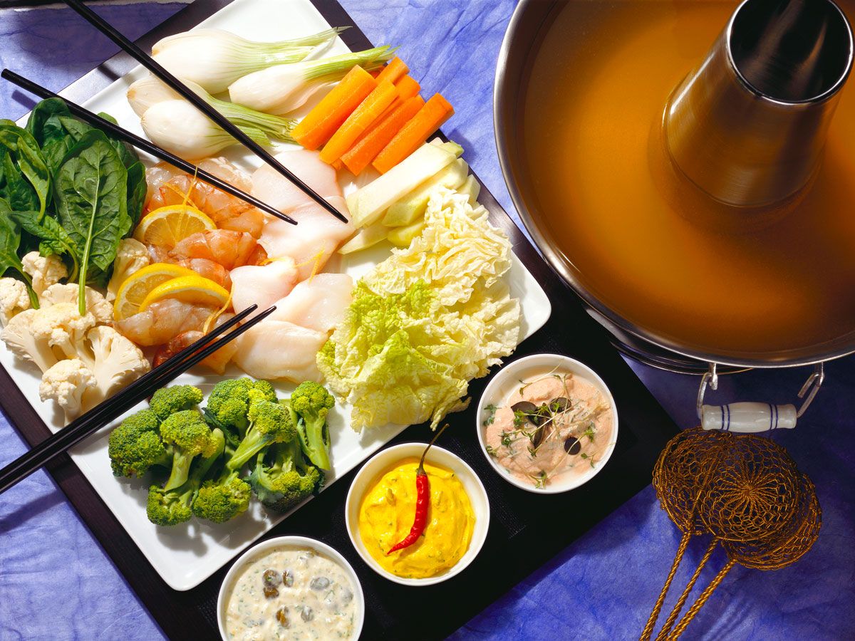 Fondue pot with ingredients on table