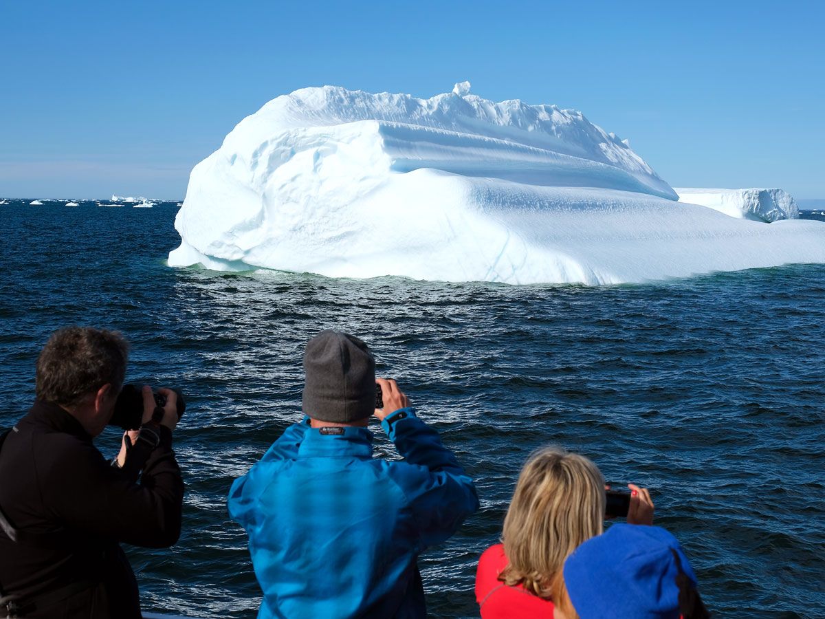 Tourists photographing iceberg in Greenland