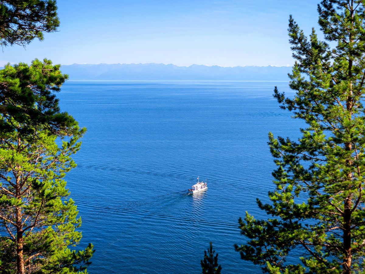 Tourist boat on Lake Baikal framed by trees
