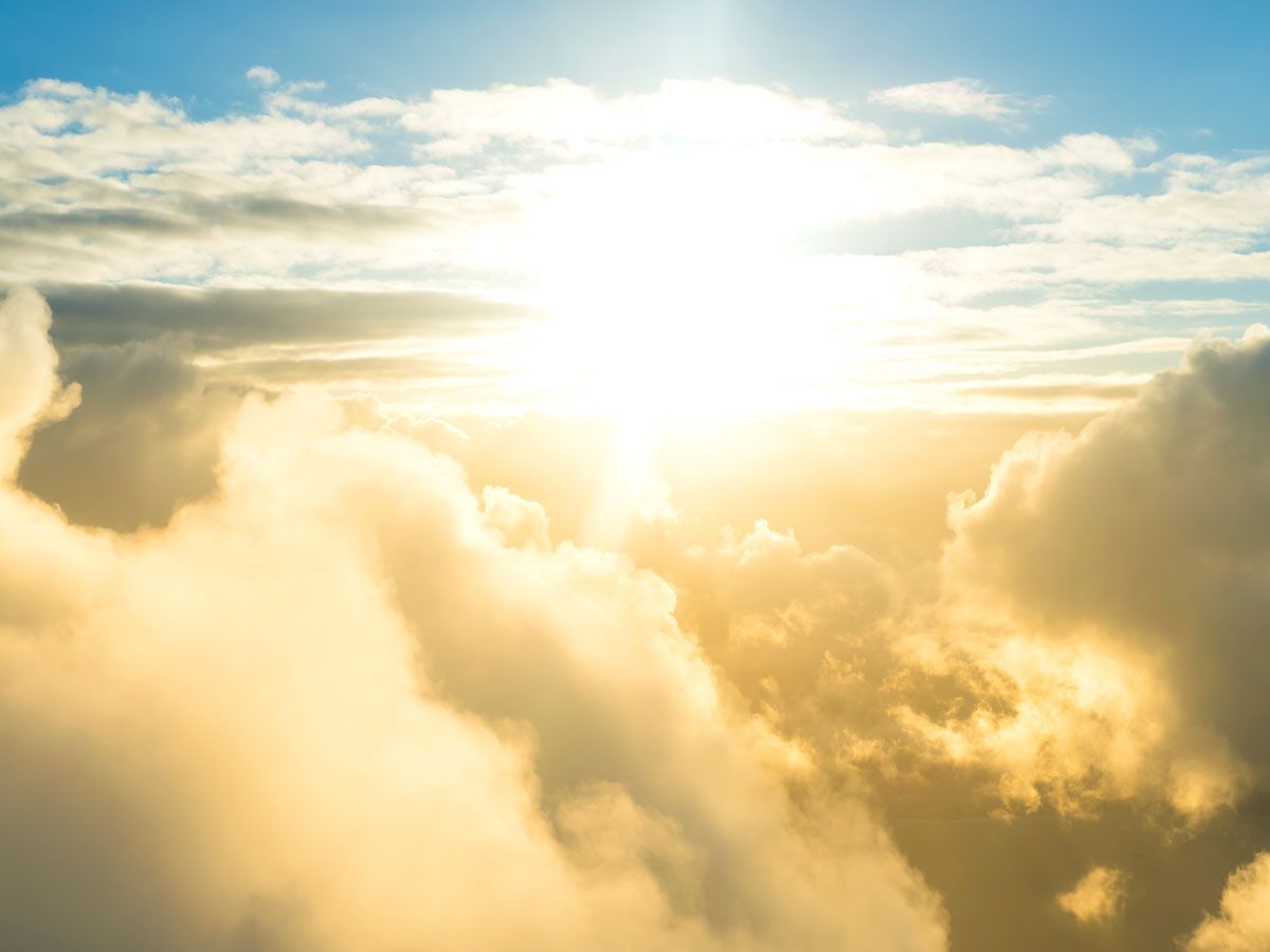 Sun shining over clouds