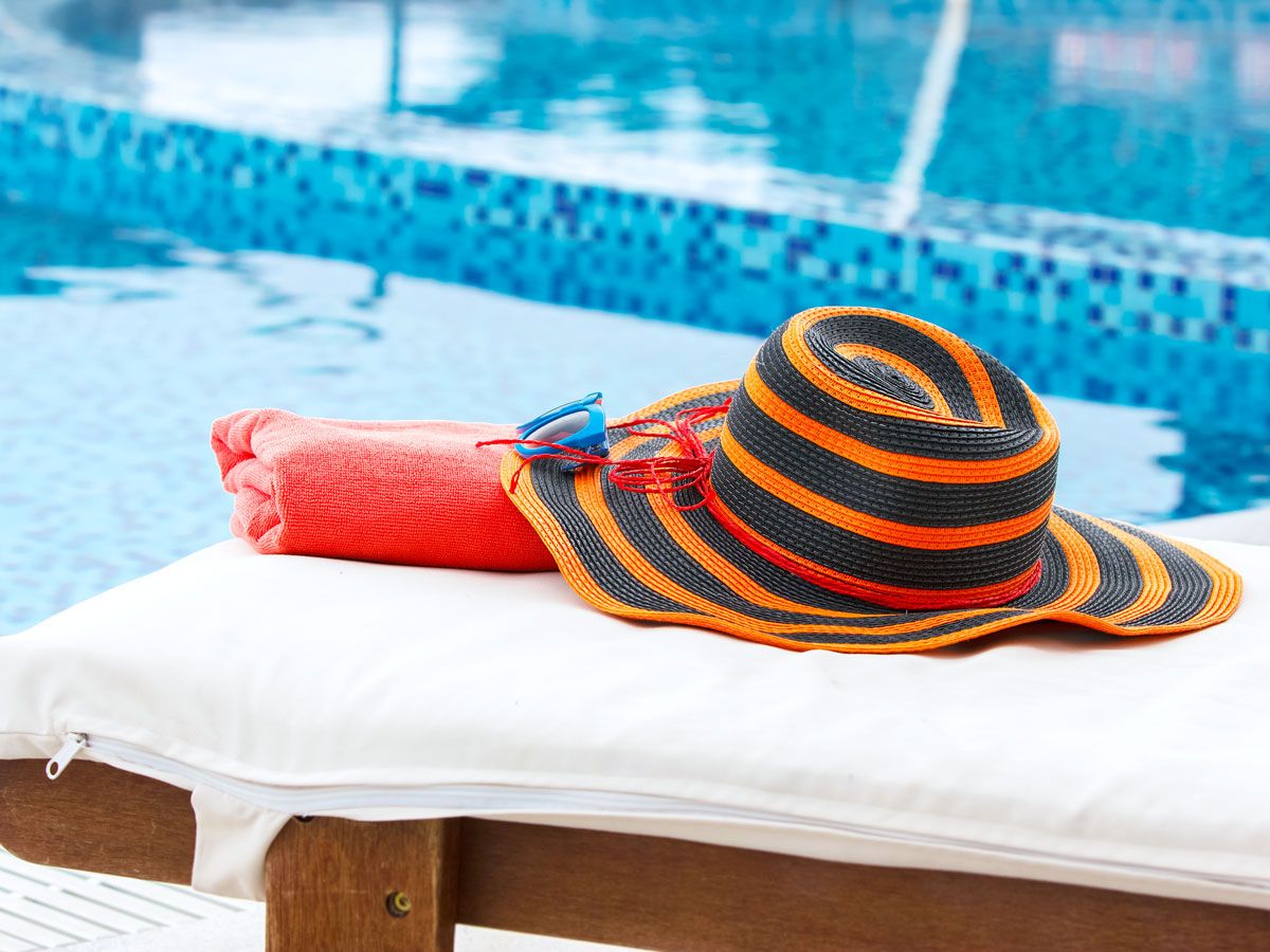 Hat and towel on pool chair at hotel