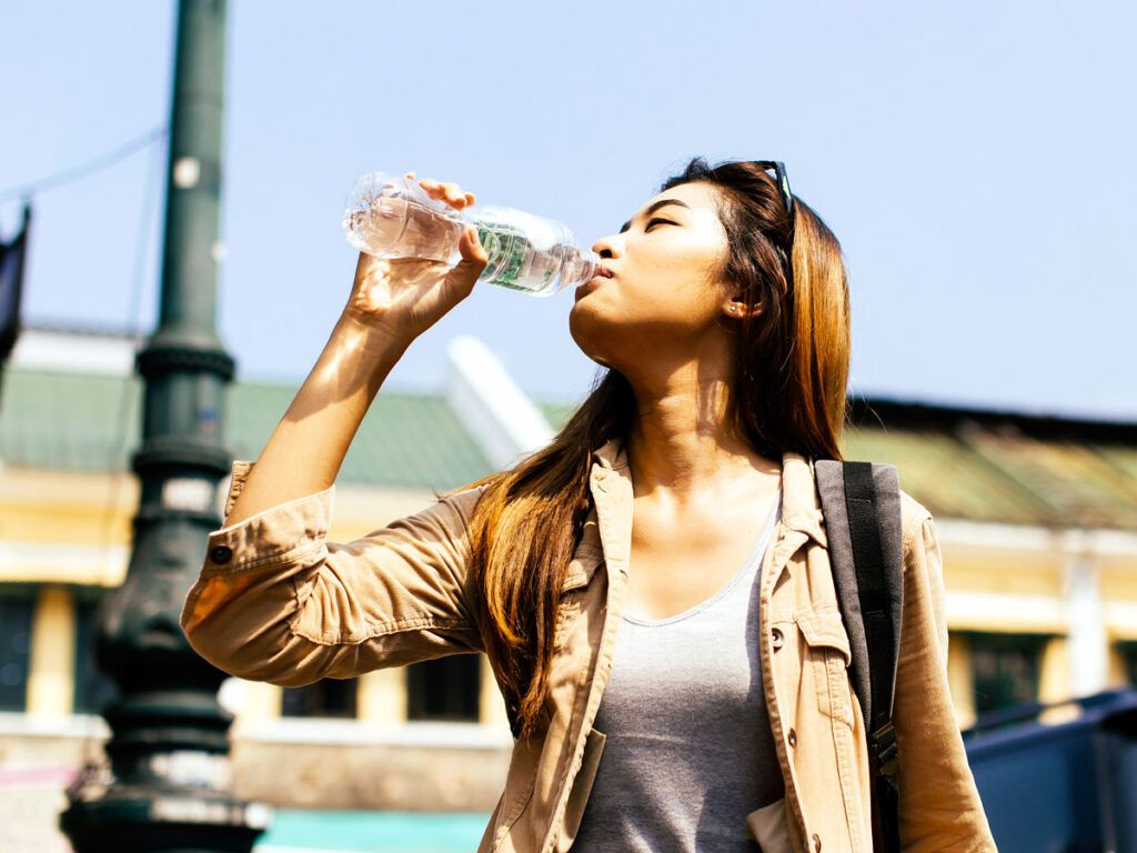 Woman drinking bottle of water outside
