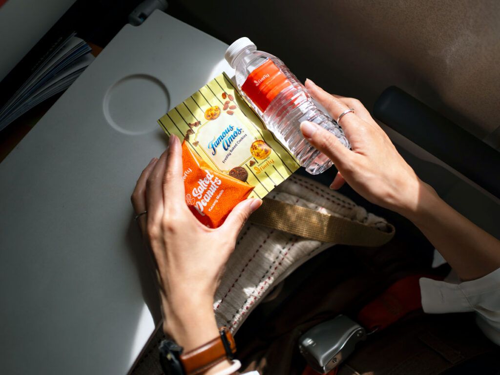 Traveler with water bottle and snacks on tray table