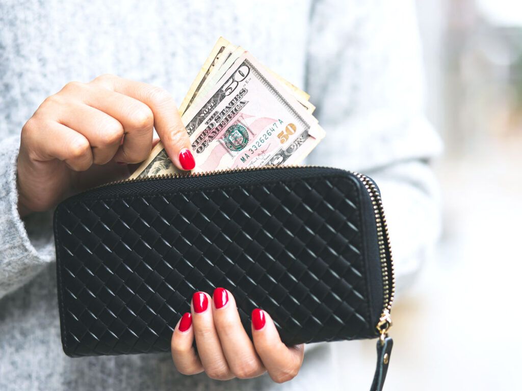 Person taking U.S. dollars out of purse