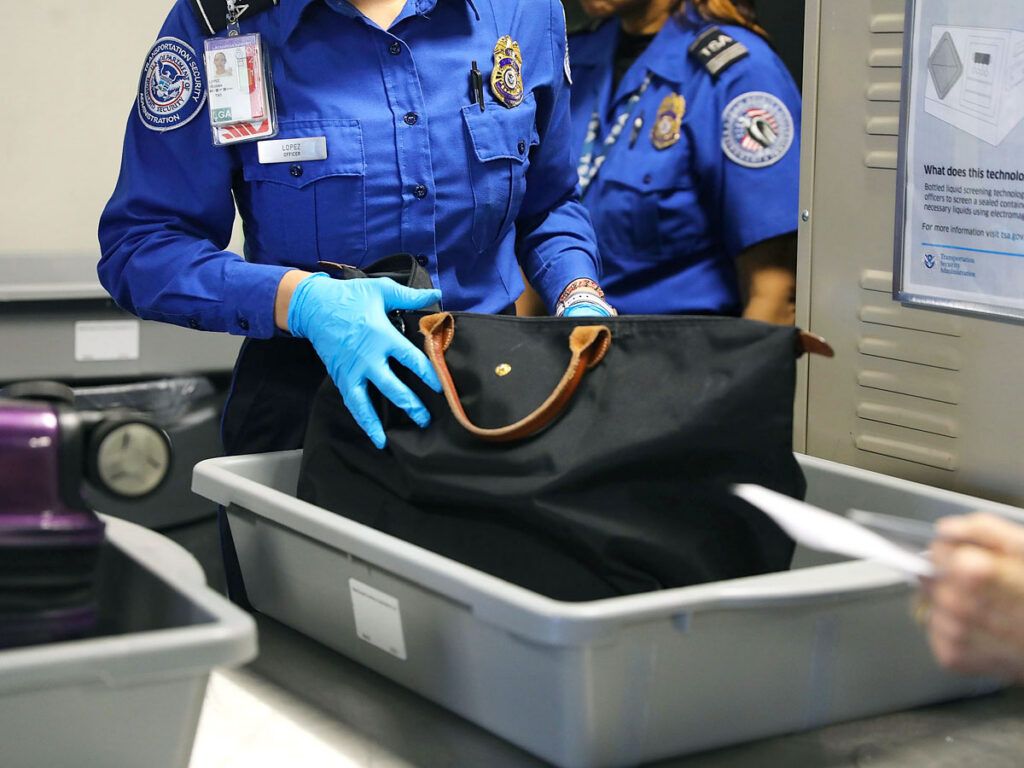 TSA officers searching passengers' luggage