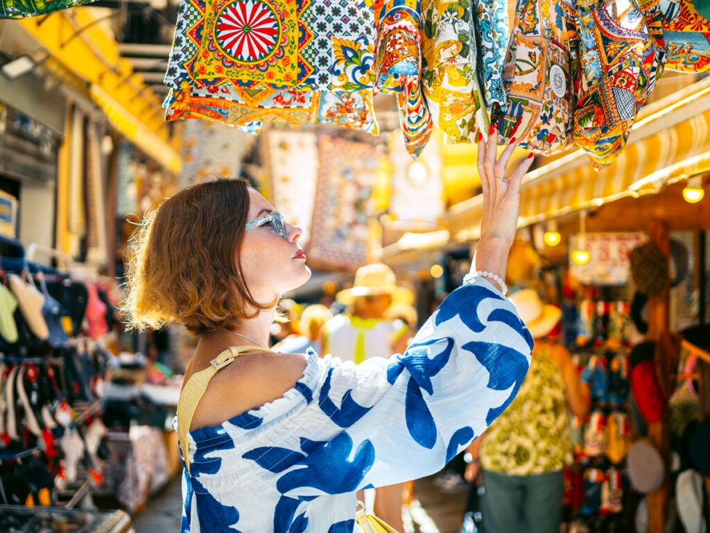 Woman browsing textiles at market stall