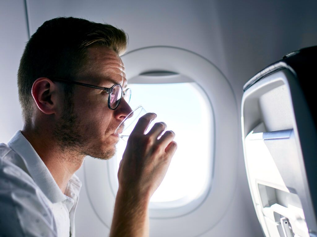Passenger in window seat sipping water