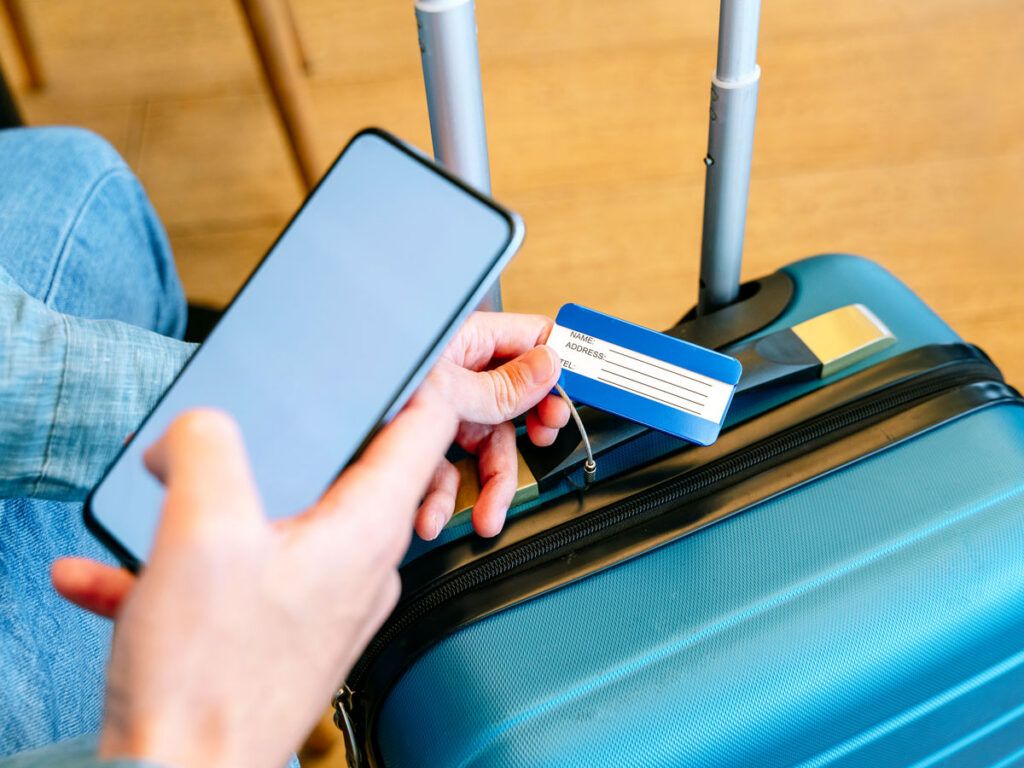Person taking photo of luggage tag on suitcase