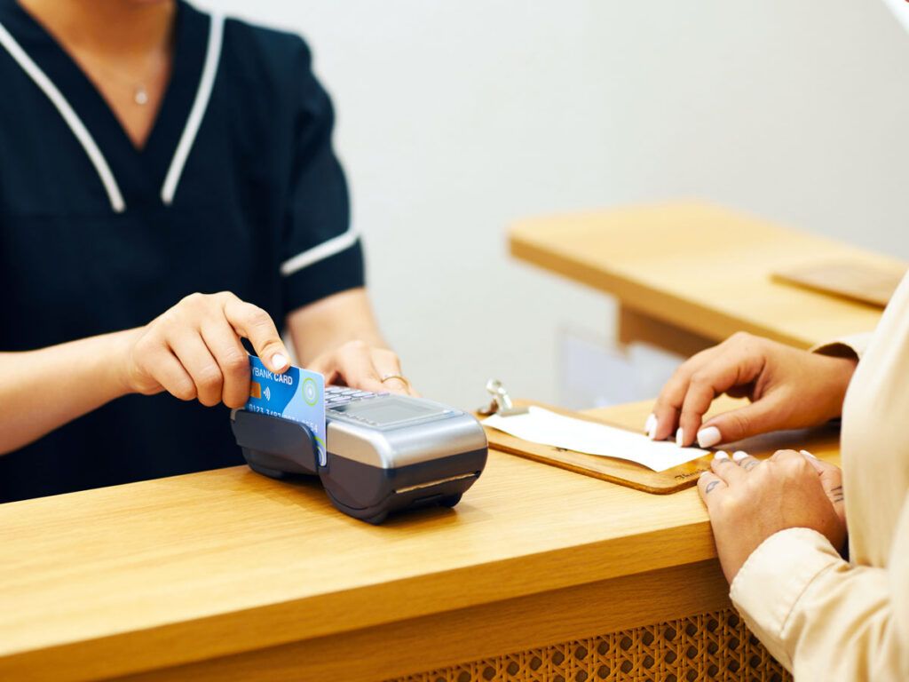 Hotel front desk employee swiping customer's credit card