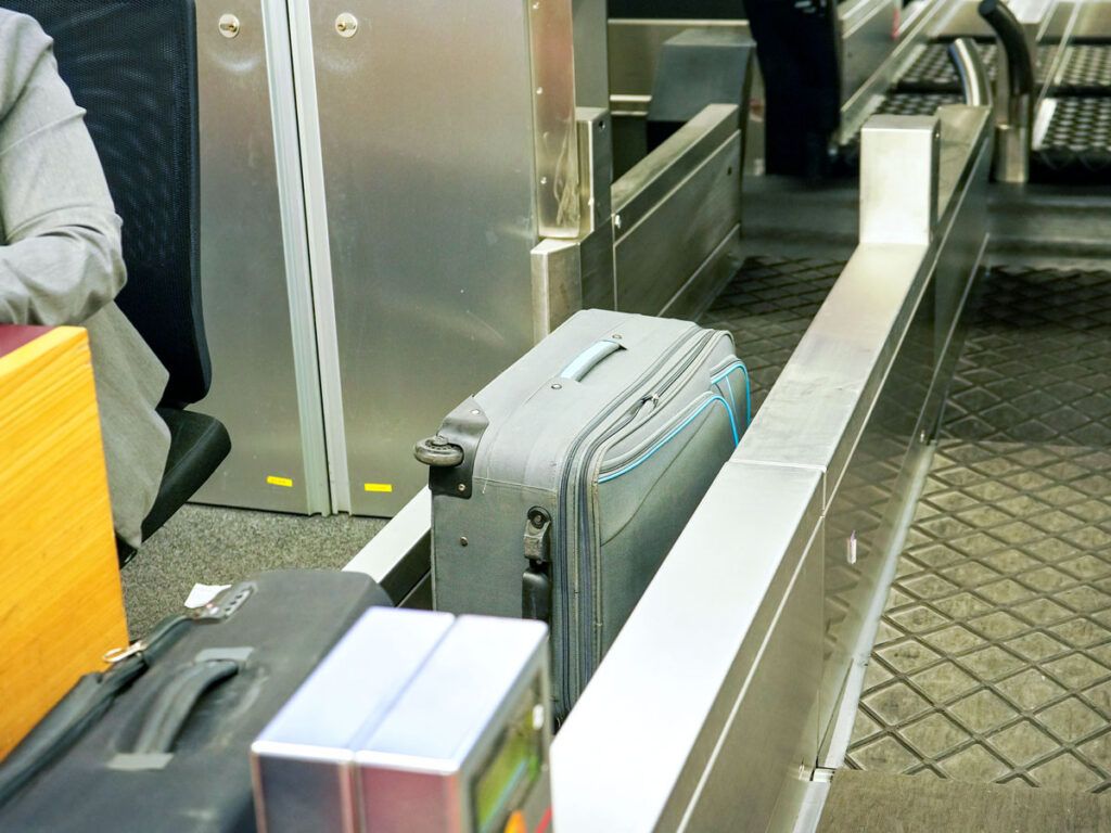Baggage loaded on conveyor belt at check-in desk