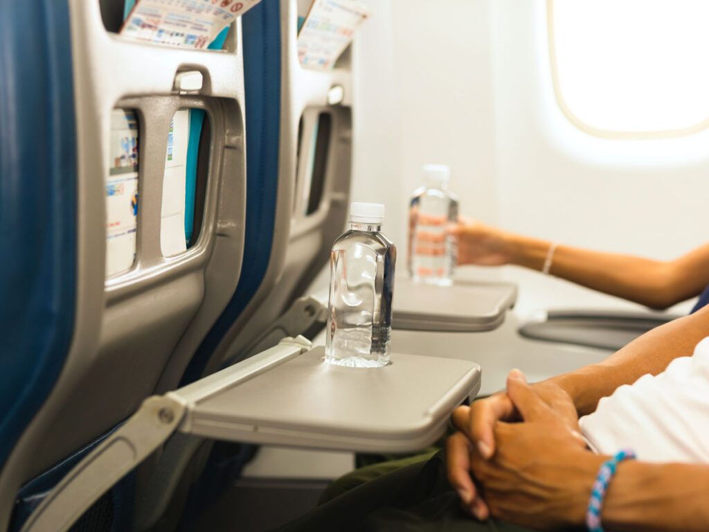 Passengers with water bottles on tray tables