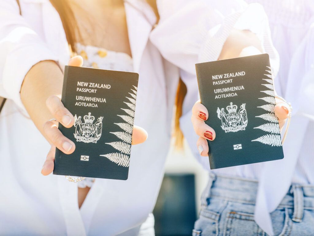 Two people holding New Zealand passports