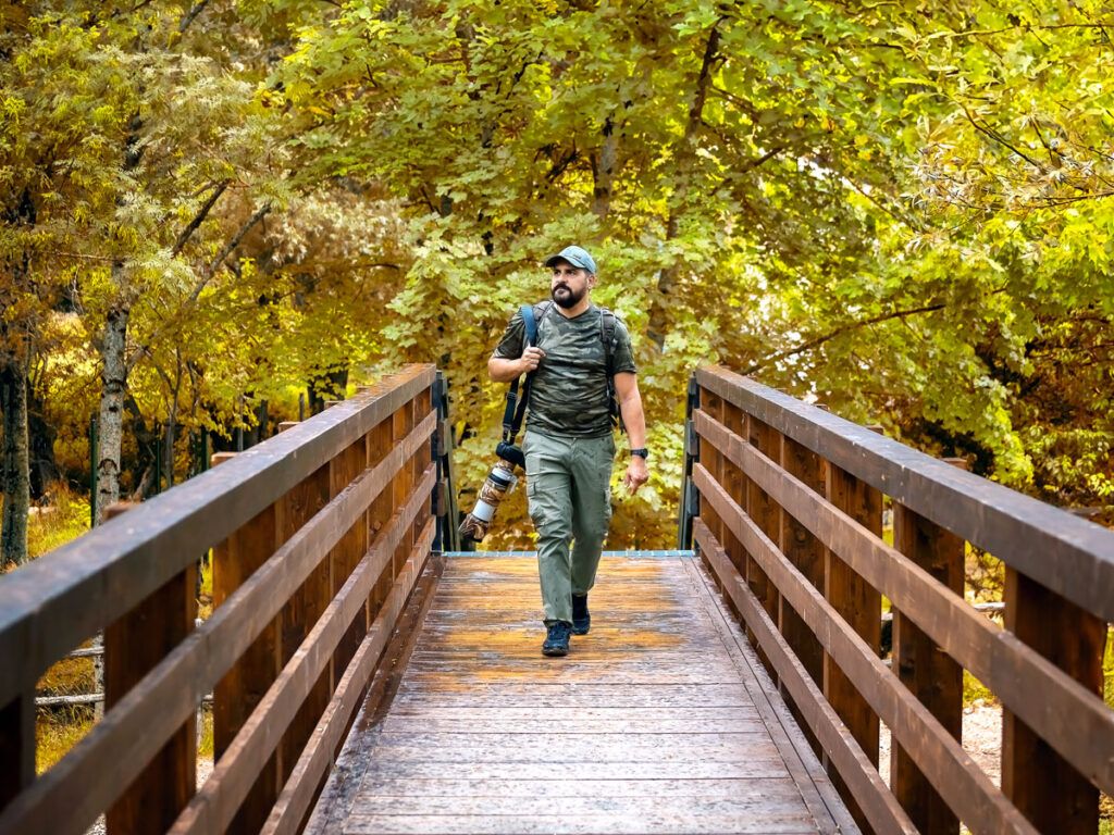 Man wearing camouflage crossing bridge