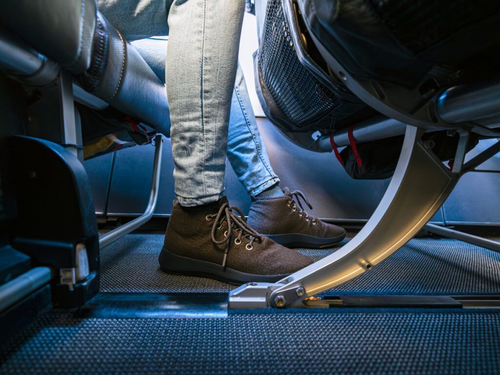 Close-up of a passenger's feet under airplane seat