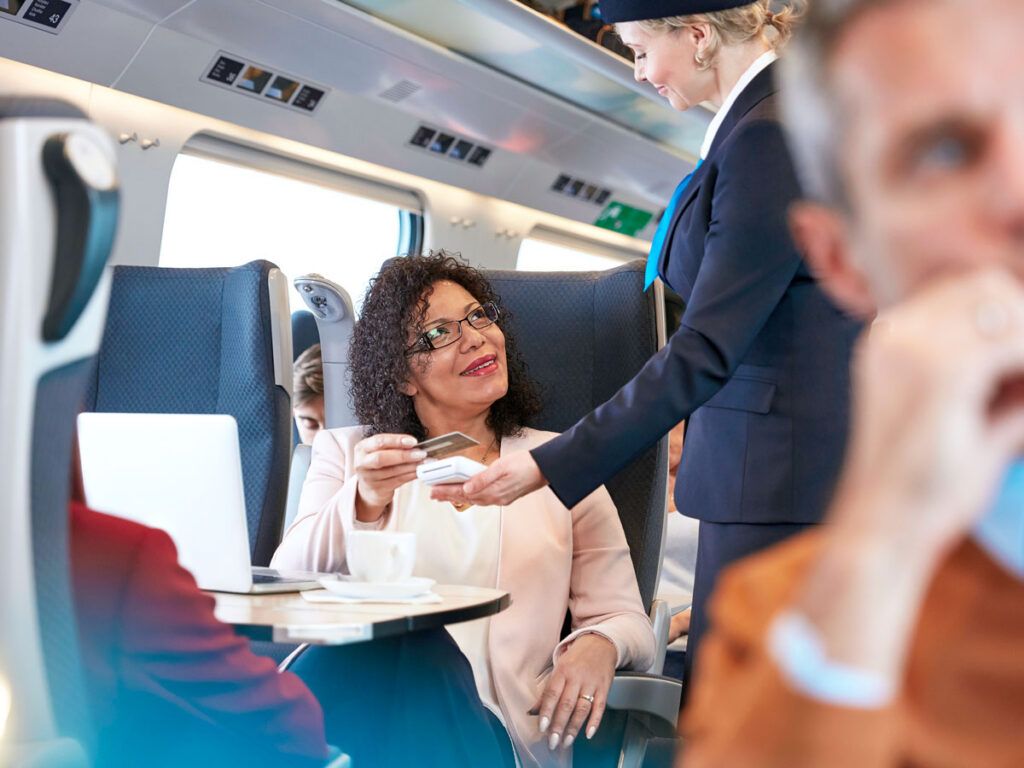 Amtrak passenger tapping credit card on payment terminal