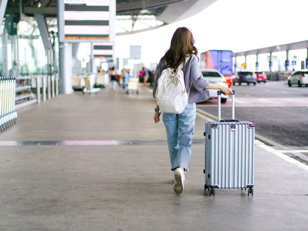 Woman with bag at curbside pick-up and drop-off area