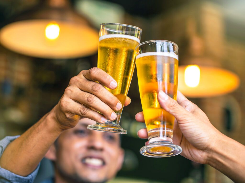 Two people clinking beer glasses
