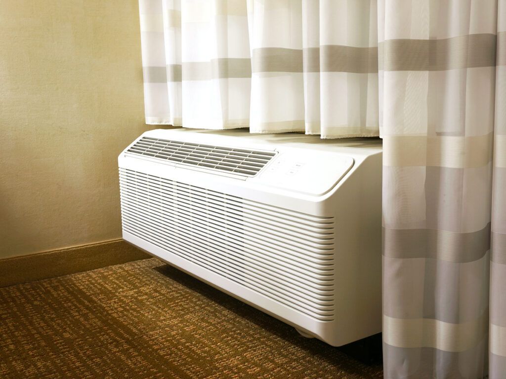 Wall-mounted AC unit in hotel room