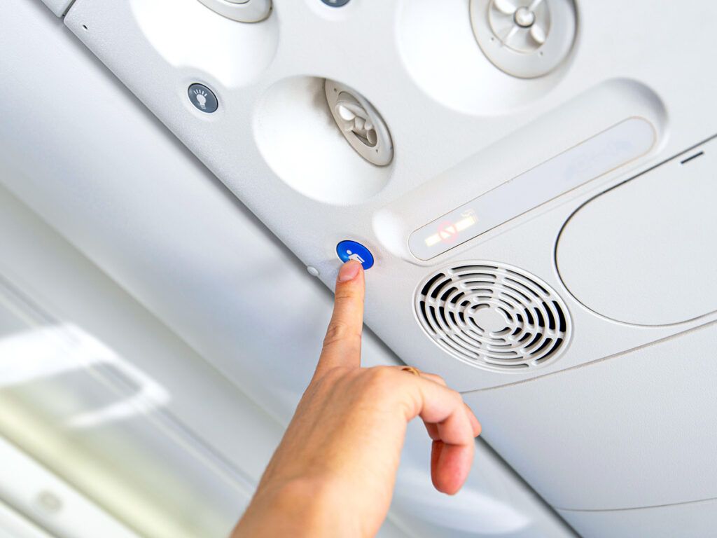 Passenger pressing flight attendant call button