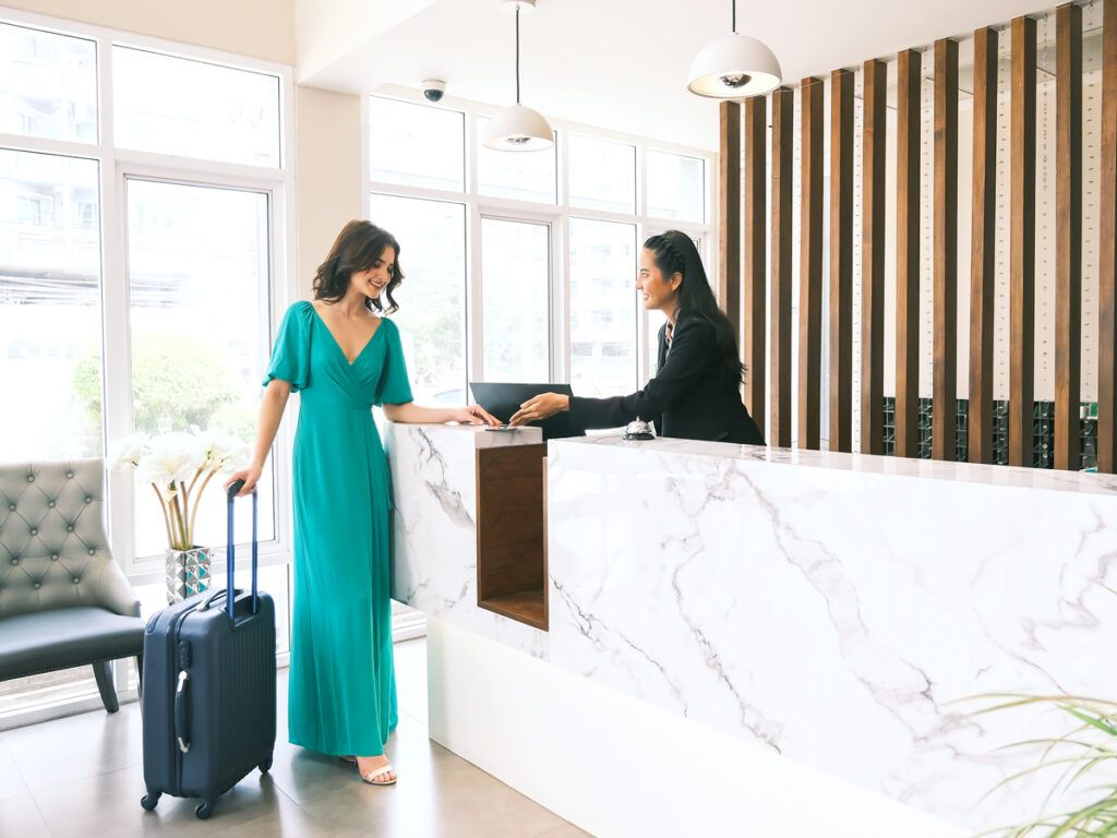 Hotel guest speaking to front desk employee