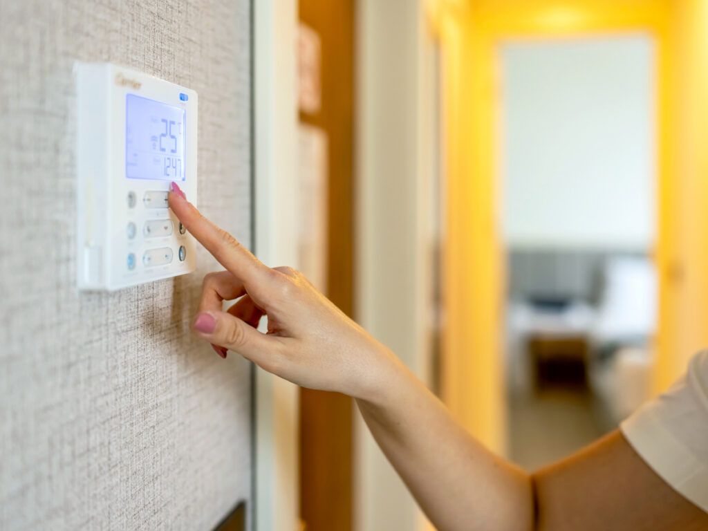 Person adjusting thermostat