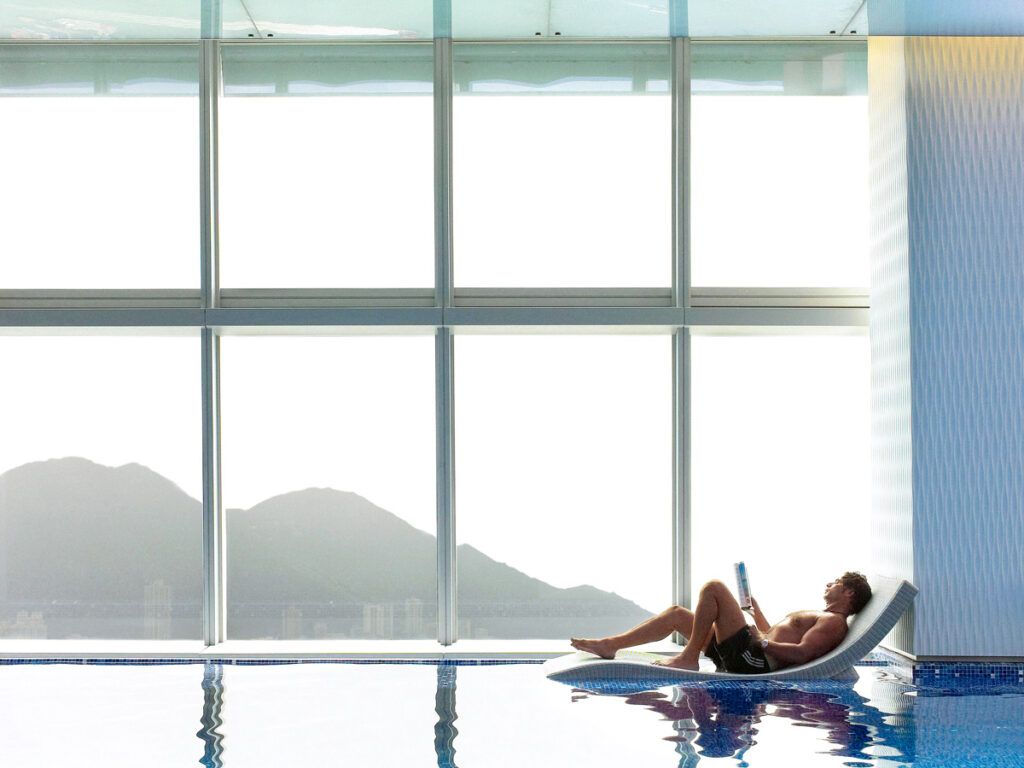 Hotel guest lounging in pool at Ritz-Carlton, Hong Kong