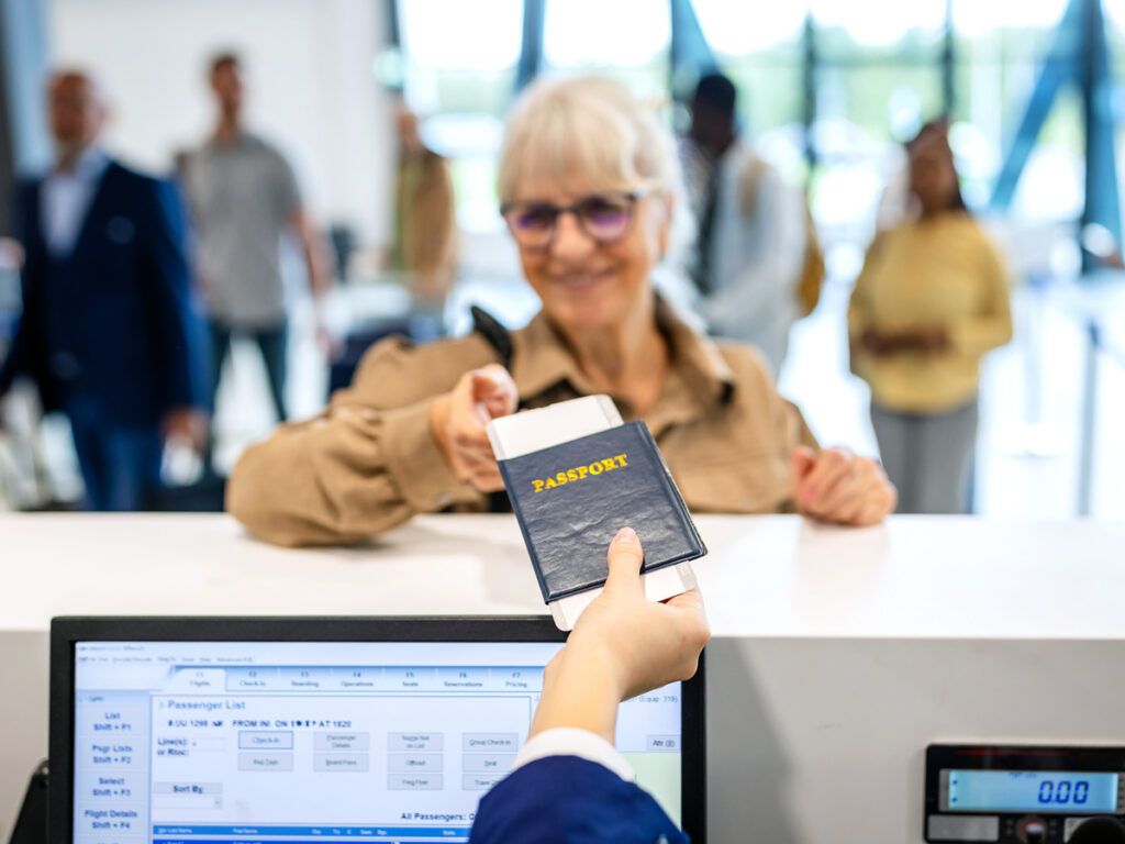 Airline agent handing passport back to passenger