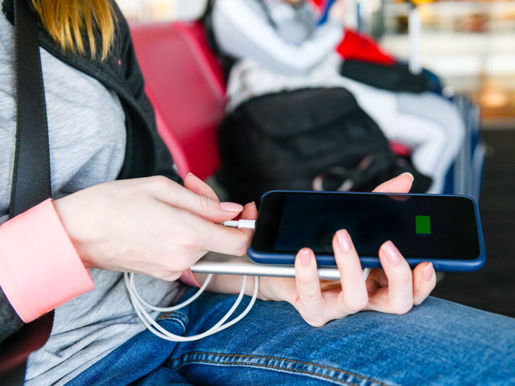 Airplane passenger plugging cellphone into power bank