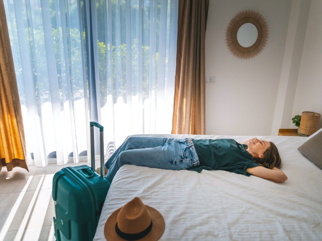 Woman lying on bed in hotel room