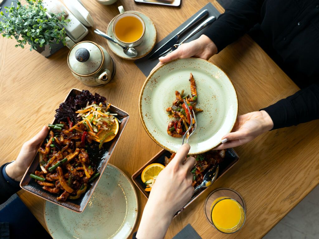Host serving food to dinner guest