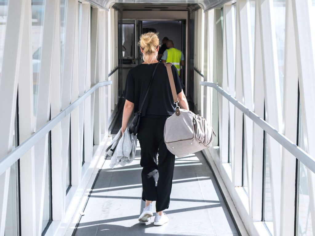 Traveler in jet bridge walking toward aircraft