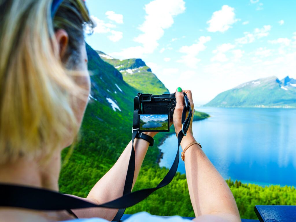 Person taking photo of lake and mountains